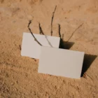 A couple of business card mock-ups on a sandy surface