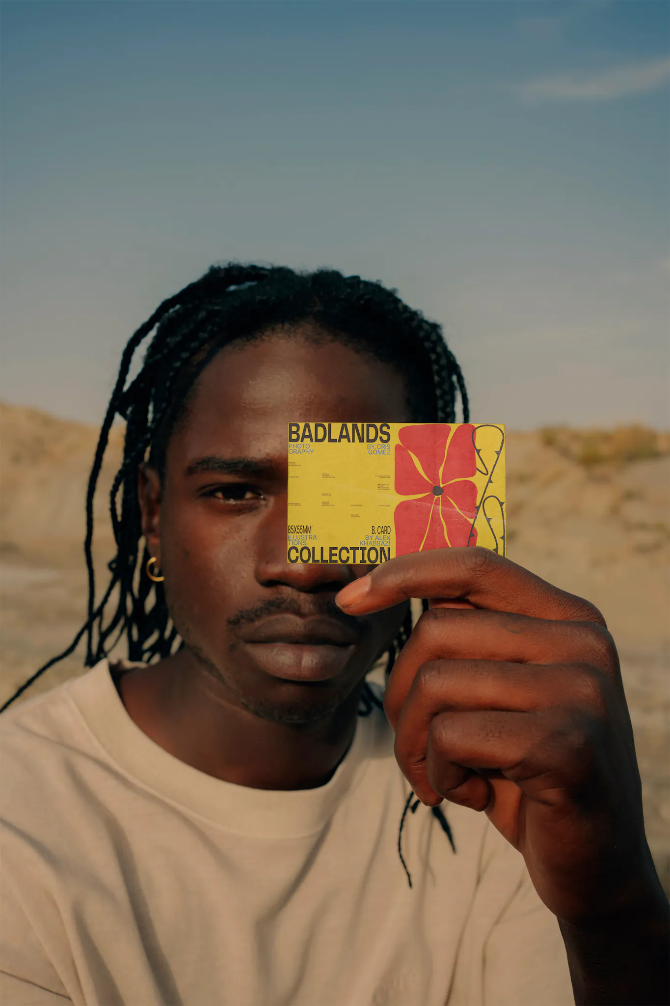 Black man holding a business card mock-up with a desert environment behind