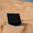 Macbook pro mock-up on a rocky surface with a blue sky behind