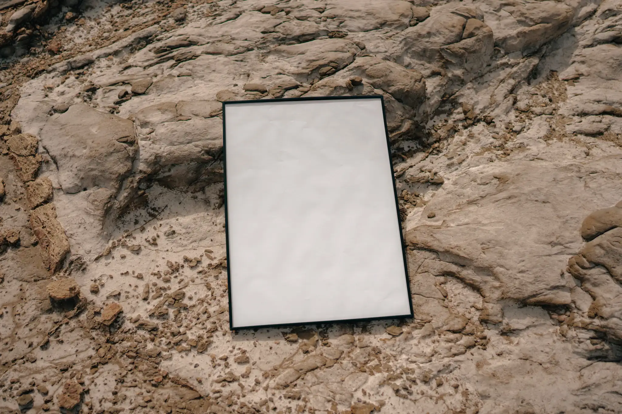 Framed poster mock-up on a rocky surface
