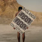 African-american person from behind holding a poster mock-up in a desert environment