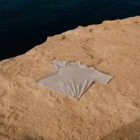 T-Shirt mock-up on a rocky surface next to the sea