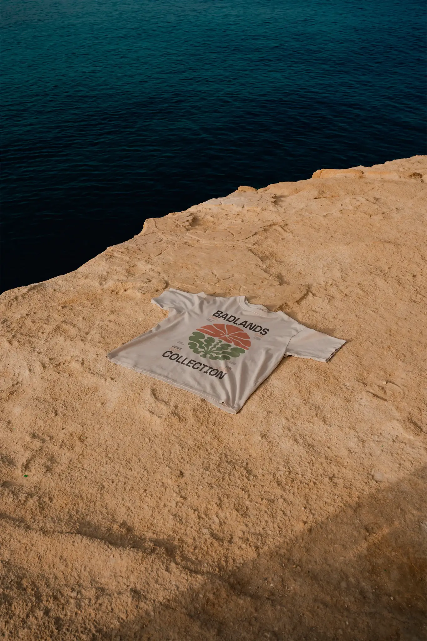 T-Shirt mock-up on a rocky surface next to the sea