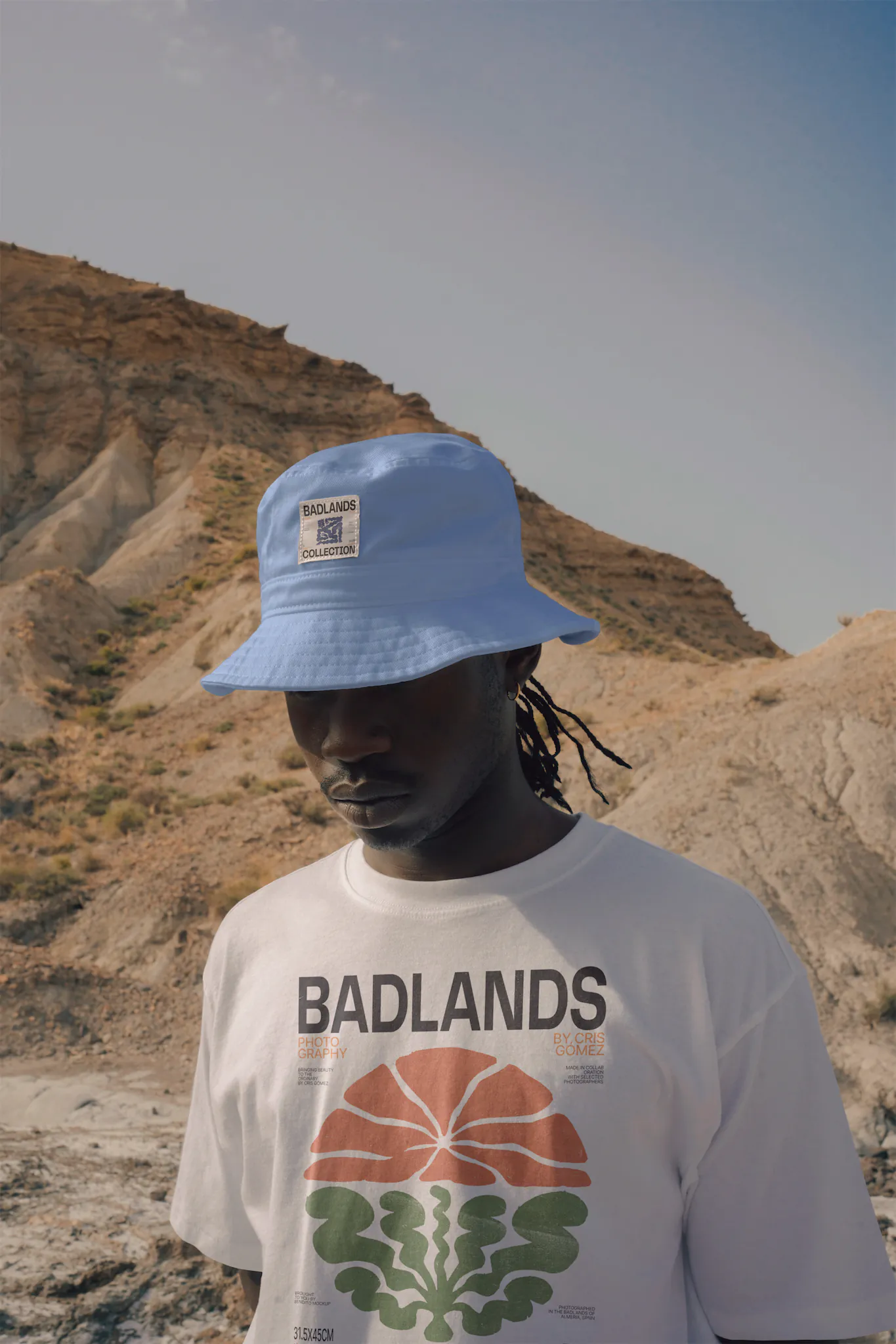 Dark-skinned person wearing a bucket hat mock-up and a t-shirt mock-up in a desert environment