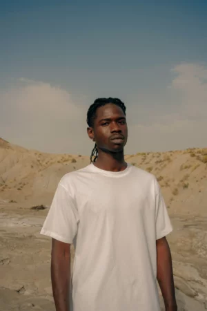 Young black man wearing a t-shirt mock-up in a desert environment
