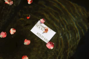 Business card mockup floating on water with rose petals.