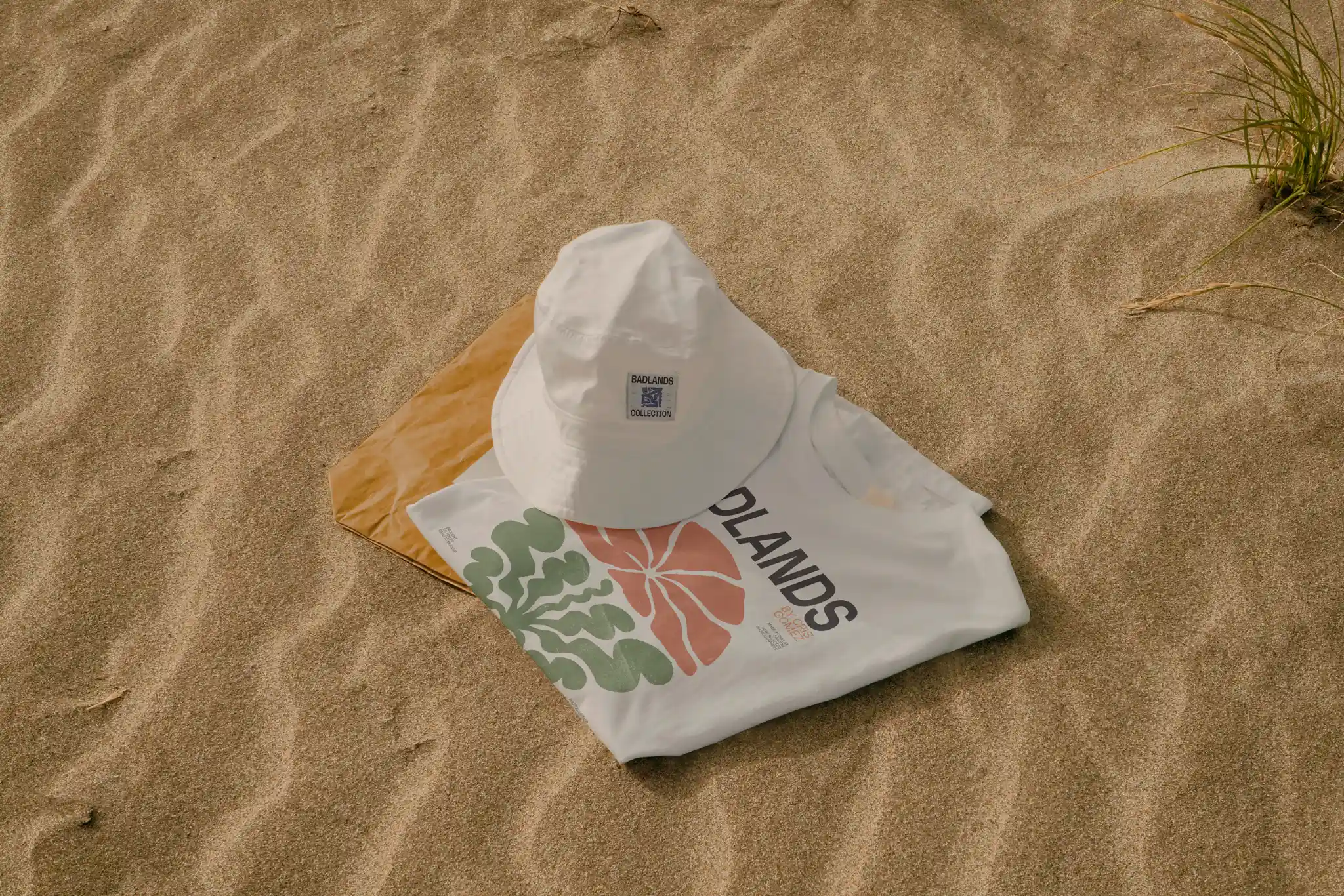 T-shirt and bucket hat mockup freebie in the sand.