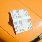 Paperback book mockup on a yellow car surface.