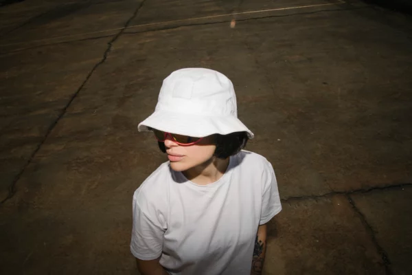 Bucket hat and t-shirt mockup worn by a female model in the street.