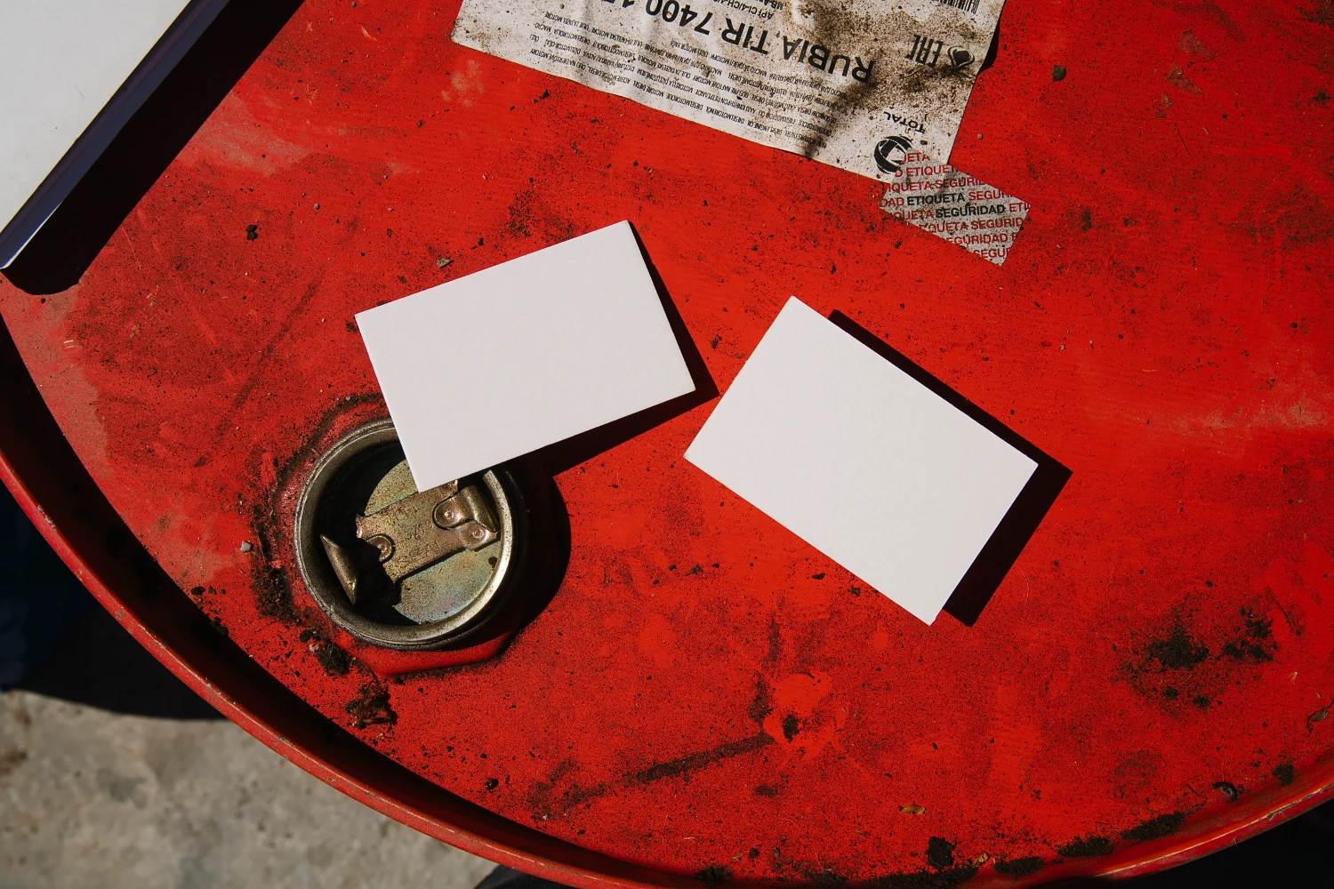 Two creative business card mockups on a rusty barrel.