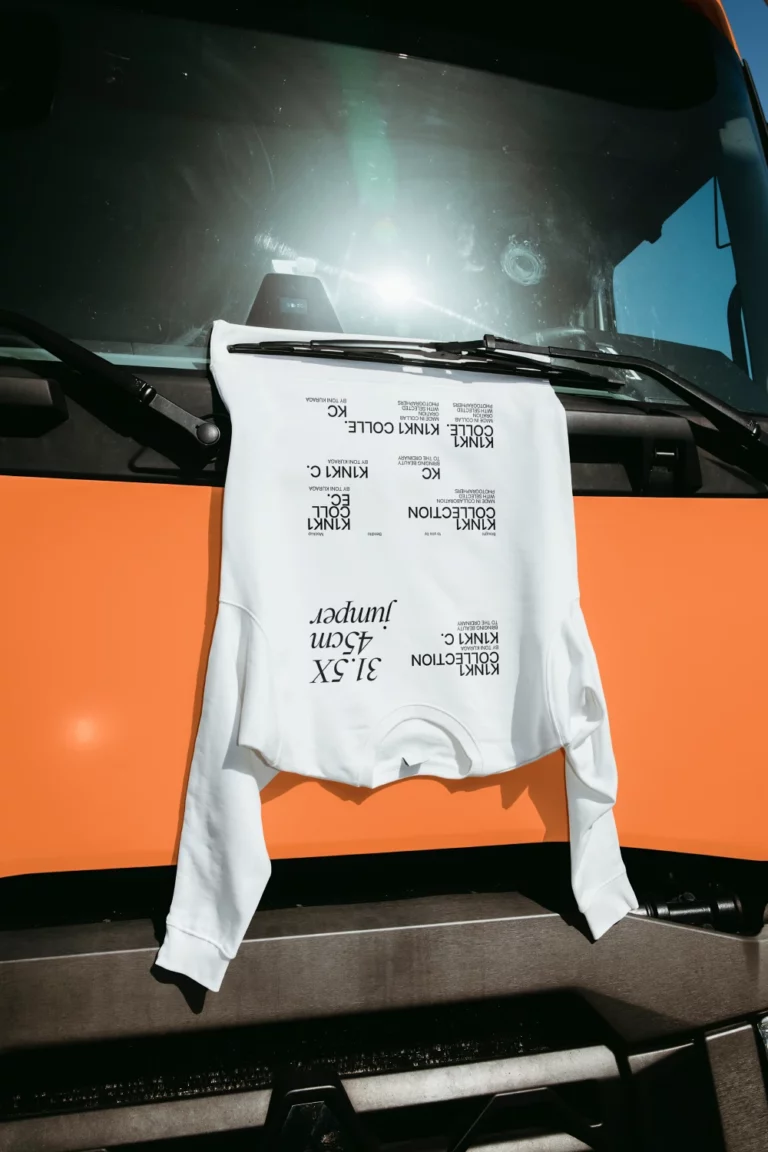 Jumper mockup facing down and hanging by a wiper blade of a truck.