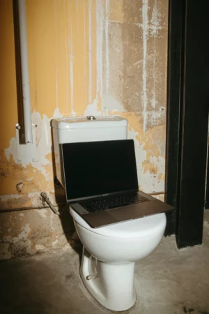 Creative Macbook Pro mockup shot with flashlight at night and placed on a toilet.