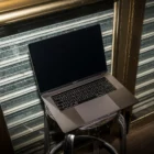 Creative Macbook Pro mockup shot with flashlight at night and placed on a metallic bar stool.