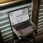 Creative Macbook Pro mockup shot with flashlight at night and placed on a metallic bar stool.