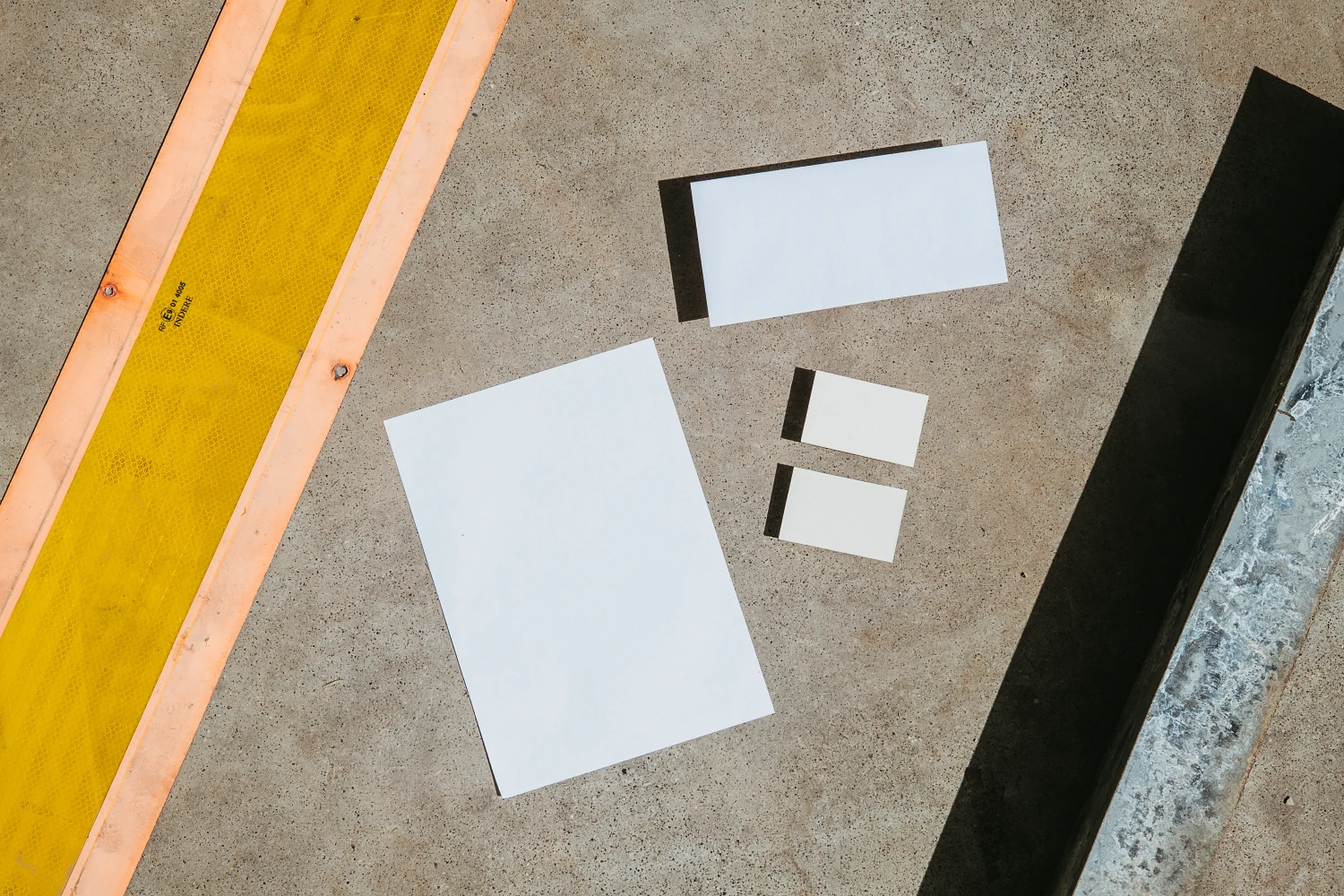 Urban stationery mockups placed in the floor and surrounded by industrial elements.