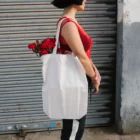 Urban tote bag mockup worn by a girl wearing streetwear.