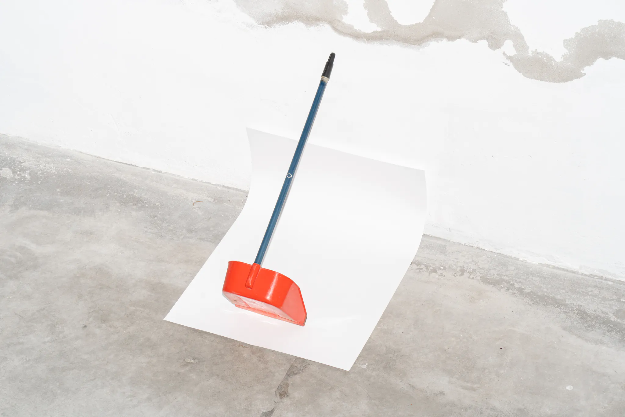 Folded poster mockup with a red dustpan on top