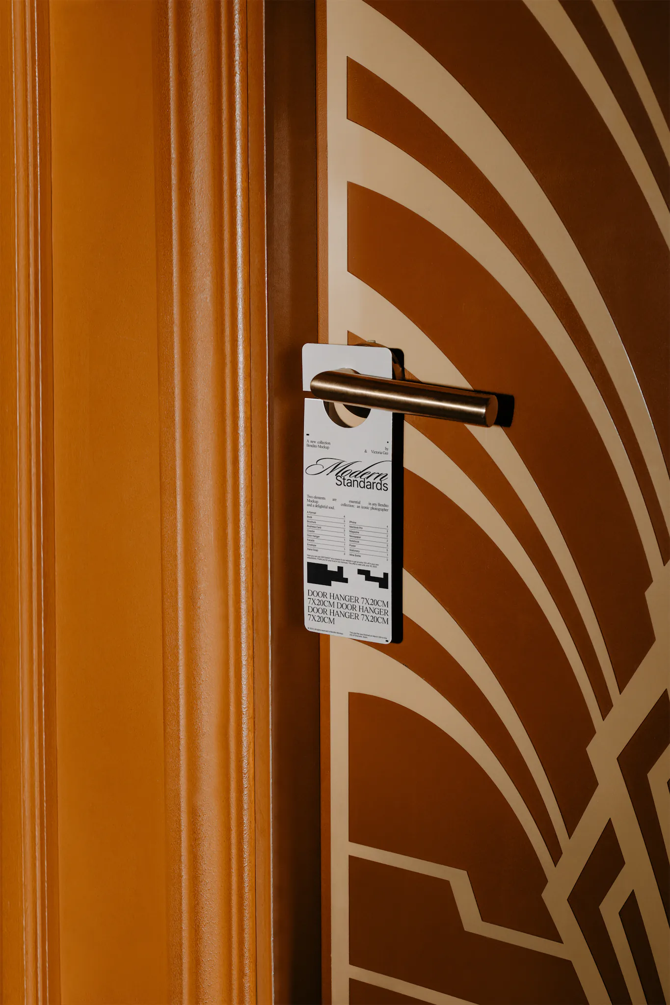 Door hanger mockup which is hanging from the doorknob of an orange door with patterns