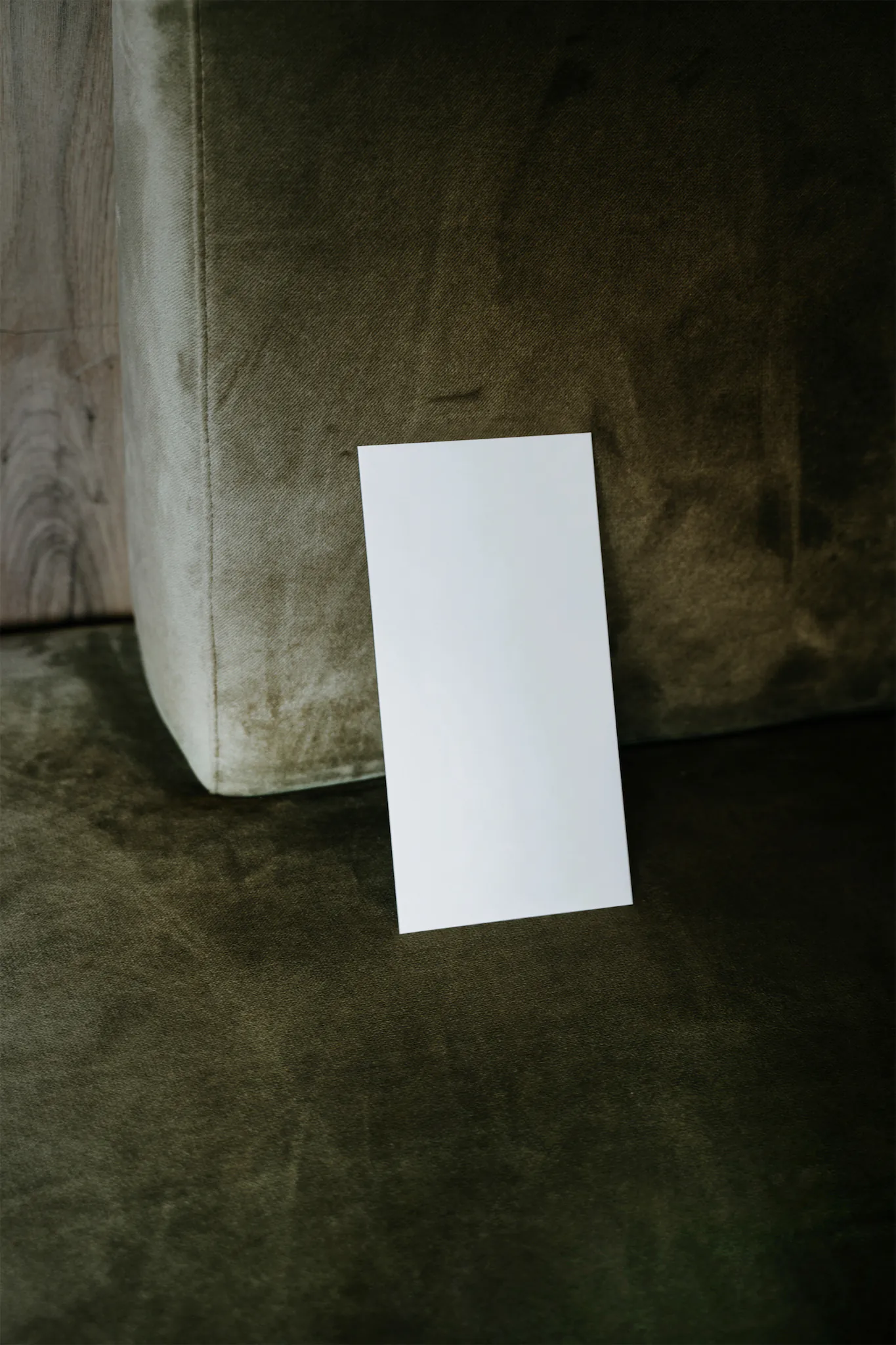 Envelope mockup on top of a fancy green couch
