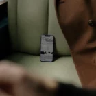 Iphone mockup on top of a green leather seat next to a brown coat