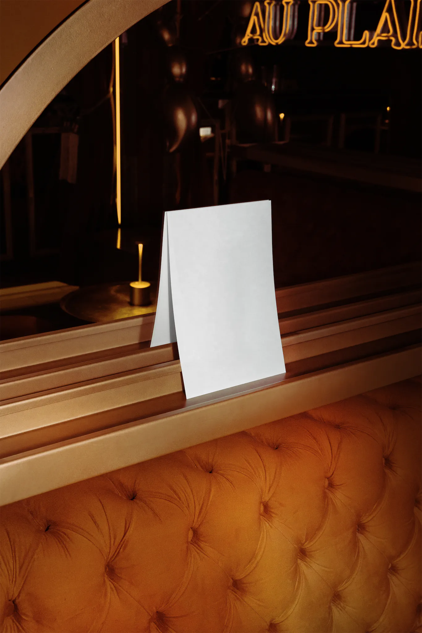A Format mockup on top of an orange couch in a fancy bar environment
