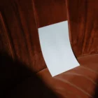 Folded A Format mockup lean on a fancy orange sofa
