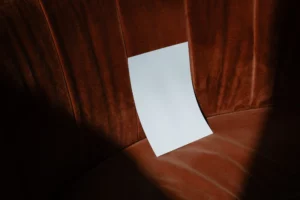 Folded A Format mockup lean on a fancy orange sofa