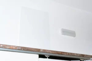 A-Format mockup on top of a sliding door gear next to a light on a white wall