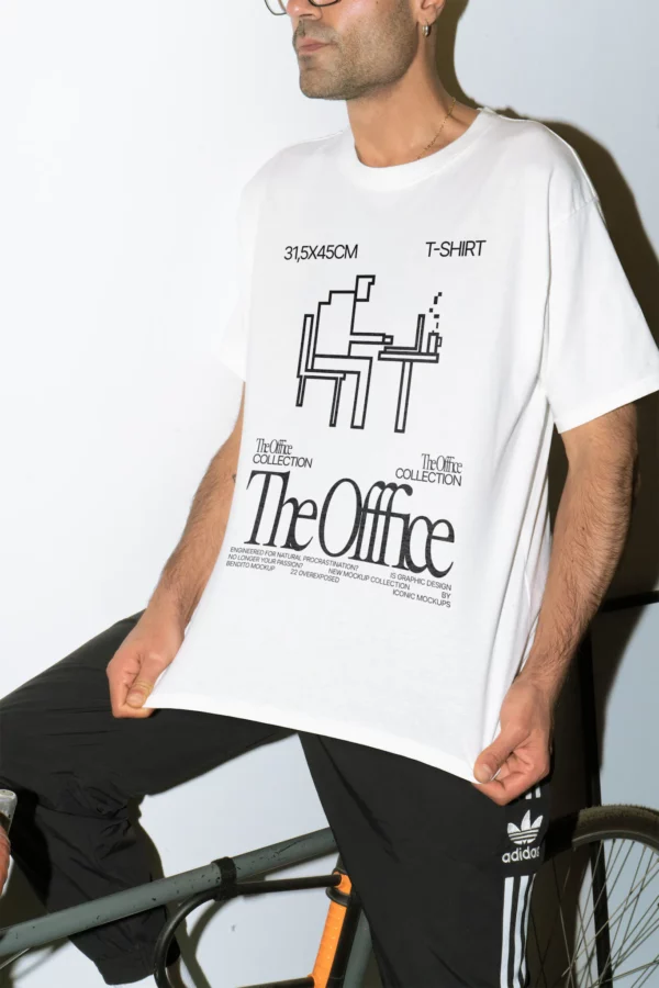 Young man with glasses wearing a t-shirt mockup sitting on a bicycle