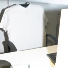 T-shirt mockup over the back of an office chair in front of a laptop