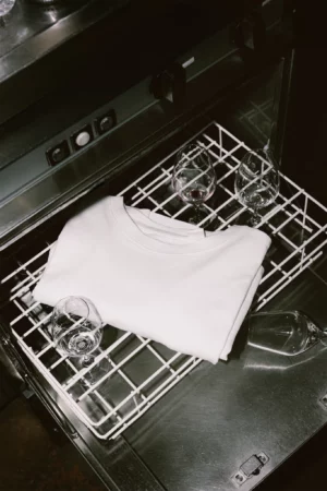 White t-shirt front PSD mockup. T-shirt mockup placed in the interior of a dishwasher, surrounded by glasses of wine. Wine merchandising mockup. Restaurant mockup. Wine bar mockup. Fashion and apparel mockup.