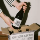Wine label PSD mockup. Wine bottle being taken out of a box mockup. Wine bottle being held by hands mockup. Wine packaging mockup. Restaurant mockup. Wine bar mockup.