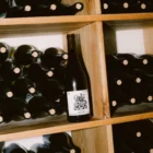 Wine label PSD mockup. Wine bottle mockup resting on a wine cellar shelf, surrounded by other wine bottles. Wine packaging mockup. Restaurant mockup. Wine bar mockup. Wine shop mockup.