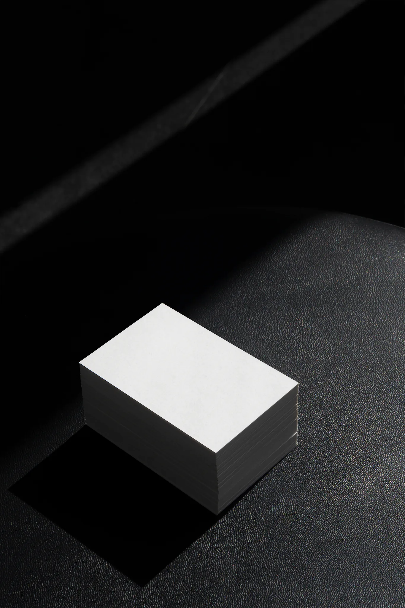 Block of business cards mockup on top of a black leather surface. Branding mockup.