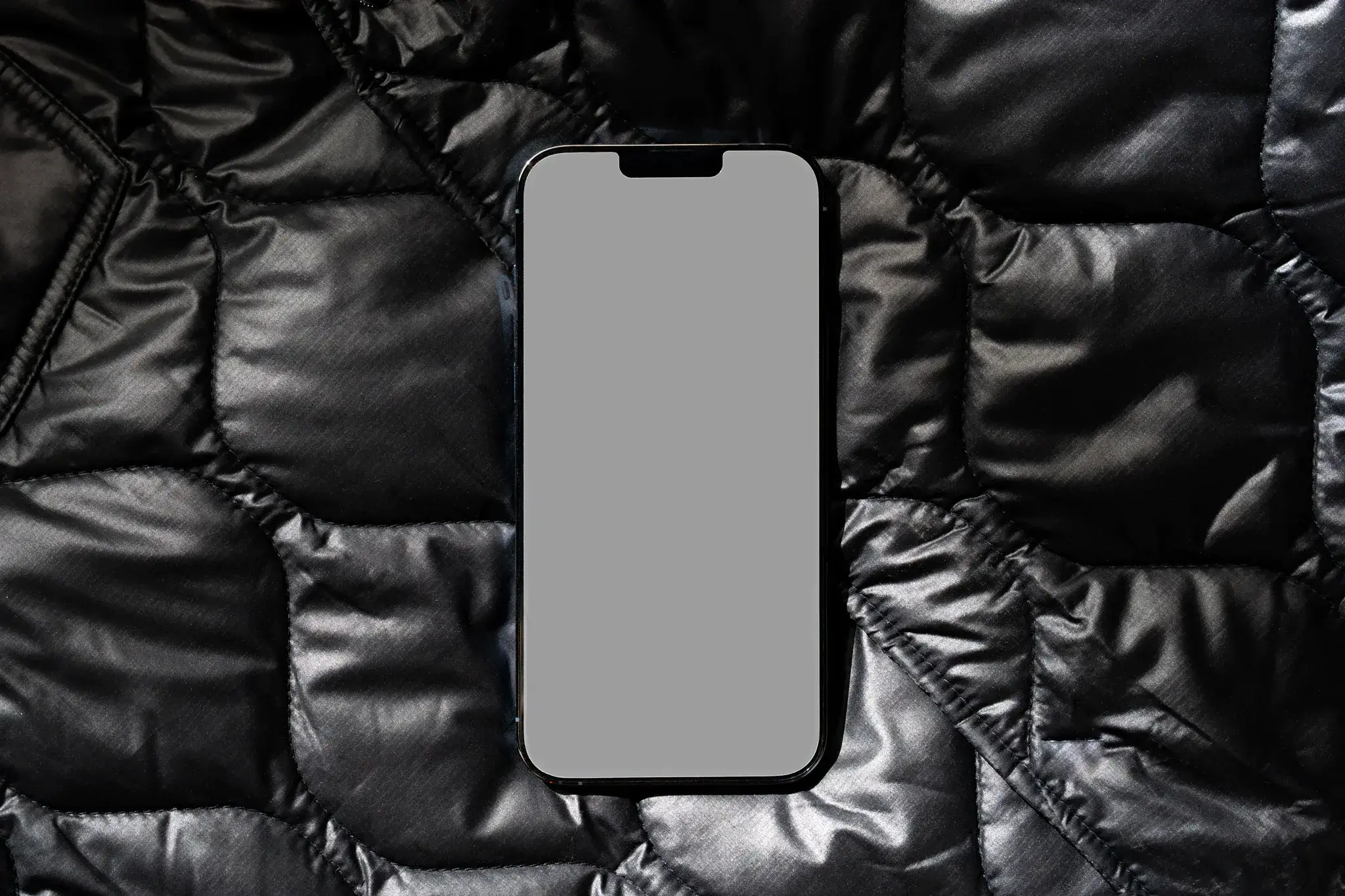 iPhone PSD mockup on top of a black jacket. Tech mockup.