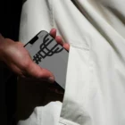 iPhone mockup. Man taking out an iPhone from the pocket of his white coat. Tech mockup.
