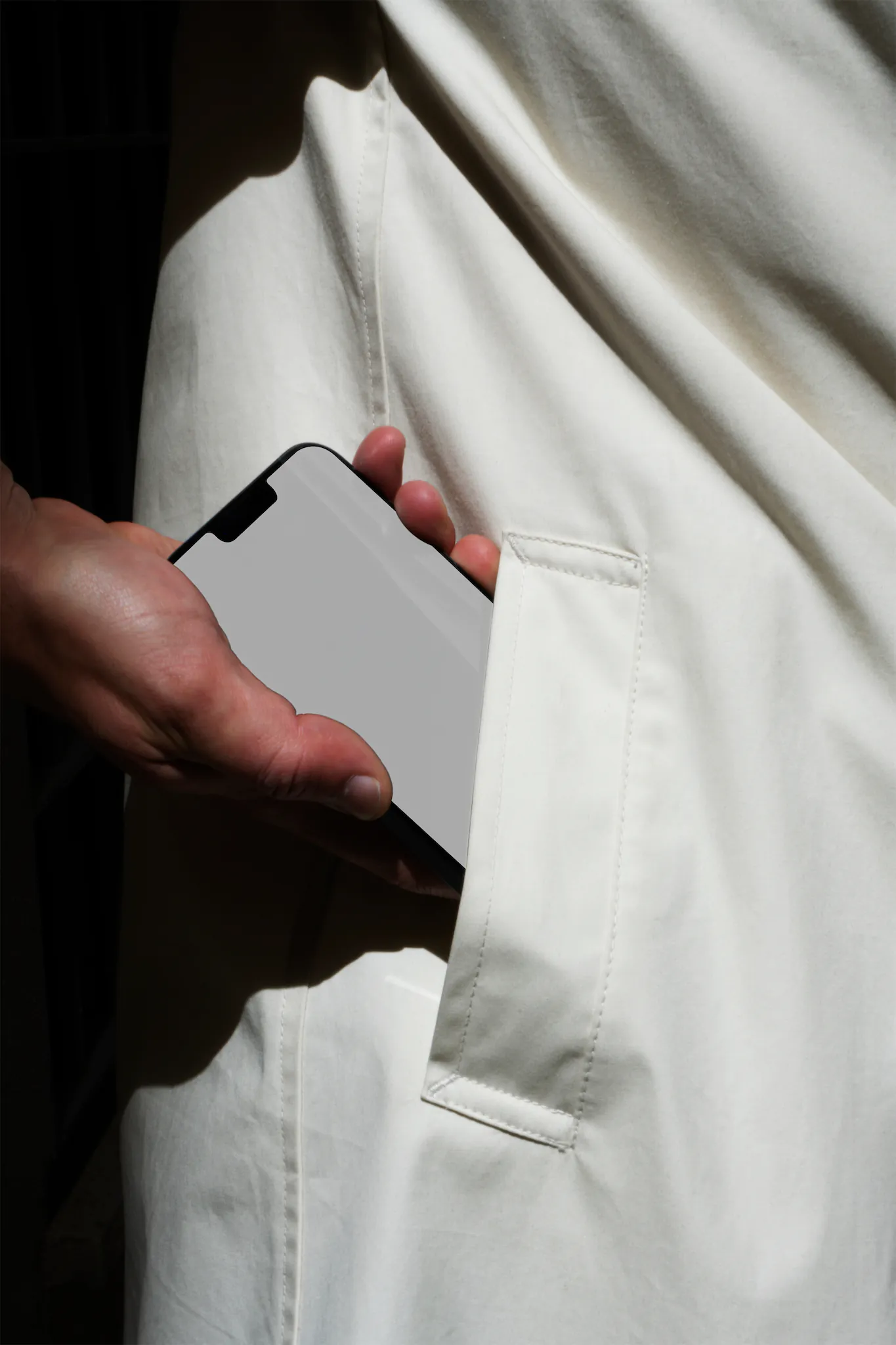iPhone mockup. Man taking out an iPhone from the pocket of his white coat. Tech mockup.