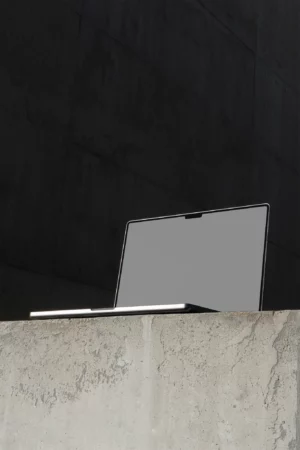 Macbook PSD mockup on top of a concrete surface in a concrete scene. Tech mockup.