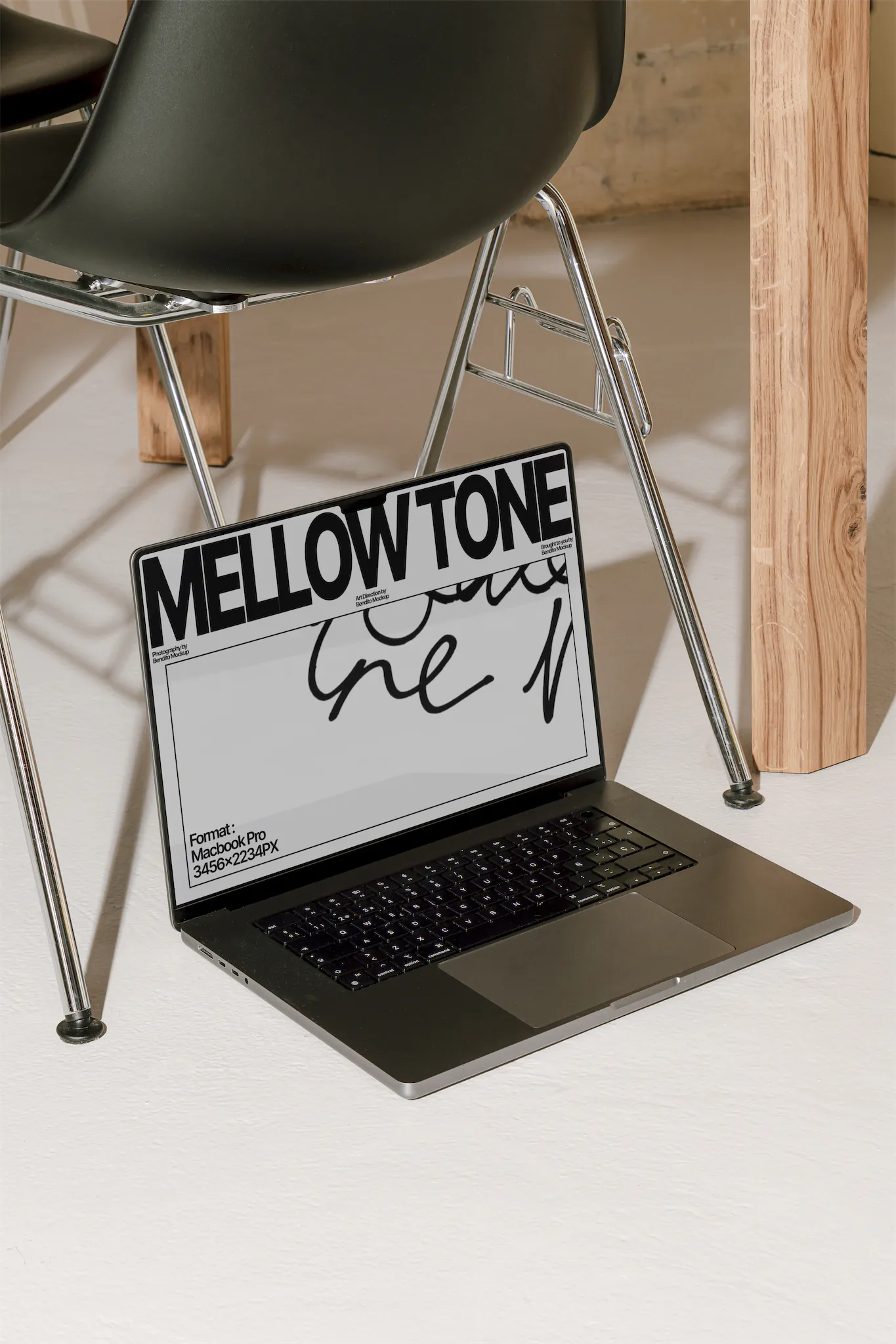 Premium macbook pro mockup placed below a metallic designer's chair. High quality macbook pro mockup resting on white concrete surface. Macbook pro mockup