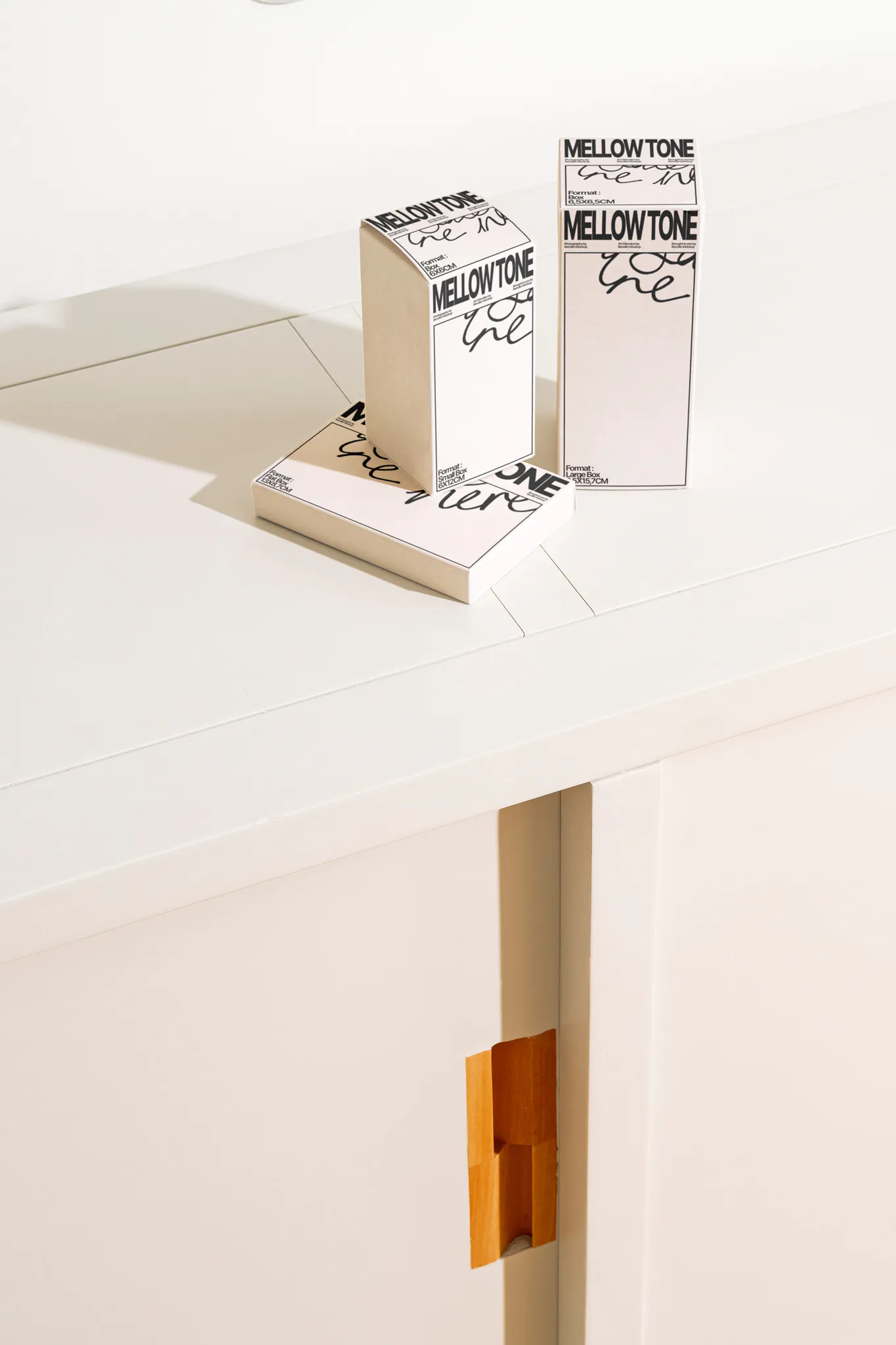 Box mockup laying on a white wooden surface. Piles of boxes mockup resting on each other with a beautiful background. Sophisticated packaging mockup laying on a wooden cabinet