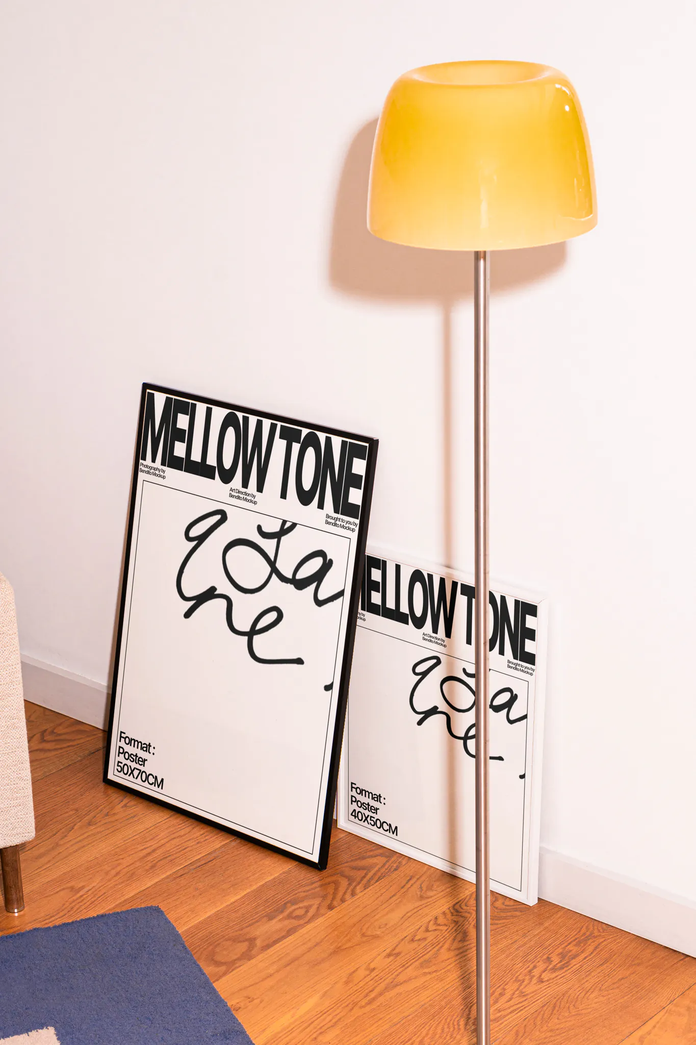Two framed poster mockups resting on a white wall