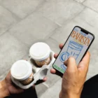 Hand holding an iPhone mockup, man holding an iPhone in the street mockup, urban mockup, street-style mockup, smartphone mockup, coffee cup mockup, packaging mockup, composition mockup, PSD file, high quality mockups, art direction.