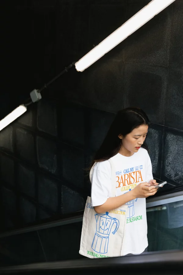 Tote-bag mockup, arms holding a tote-bag mockup, woman wearing a tote-bag mockup, woman in the street with a tote-bag mockup, girl getting out of the subway while holding her tote-bag mockup, aesthetic background, real photography, natural shadows, urban aesthetic mockup, clothing mockup, fashion mockup, high quality mockup, PSD file.