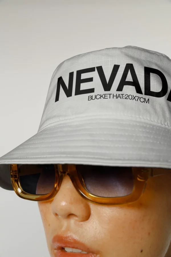 Woman wearing a bucket hat mockup and shades, apparel PSD file, bucket hat mockup, clothing mockup, fashion mockup, apparel mockup, premium quality mockup.
