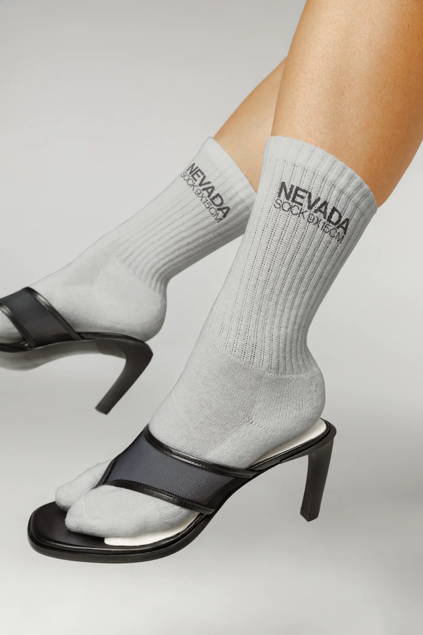 Close-up of the legs of a female wearing high sandals on white socks mockup, PSD file of white socks mockup, high fashion mockup, apparel mockup, white socks mockup, premium quality socks mockup.