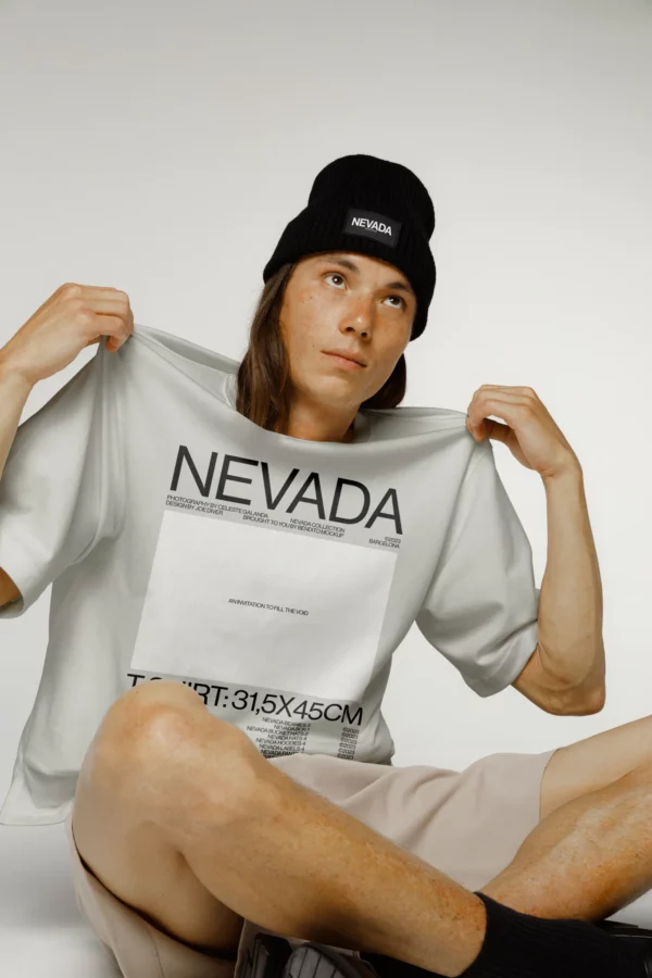 Guy with long hair sitting on the floor with a white t-shirt mockup and black beanie mockup, PSD file of a guy wearing a t-shirt mockup, clothing mockup, high fashion mockup, t-shirt mockup, beanie mockup.