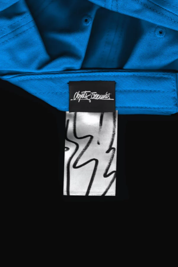 Scanned label of a hat mockup. Top-down view of the label of a cap mockup. Realistic hat mockup flattened by a scanner effect. Minimalistic cap mockup for Adobe Photoshop, black background. Premium quality mockup.