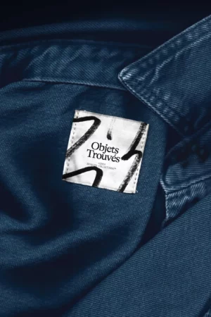 Mockup of fabric label on a blue denim shirt, mockup of square label with scanned effect, mockup of flattened label next to the collar of a shirt. High quality mockup for Adobe Photoshop.