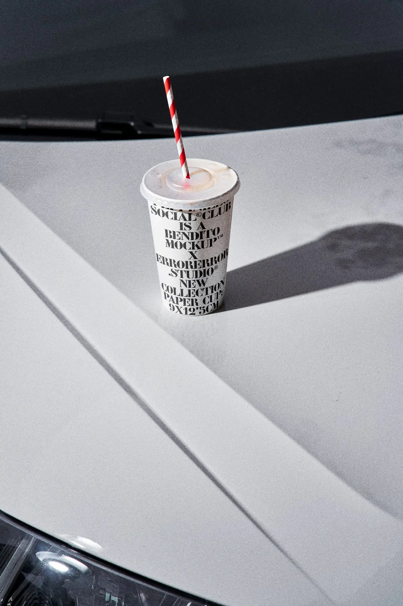 Disposable paper cup mockup over the hood of a white car in the parking of a fast food restaurant. Paper cup mockup. Paper cup PSD file. Drink mockup. Fast food mockup. Takeway mockup. Premium quality disposable paper cup mockup for Adobe Photoshop.