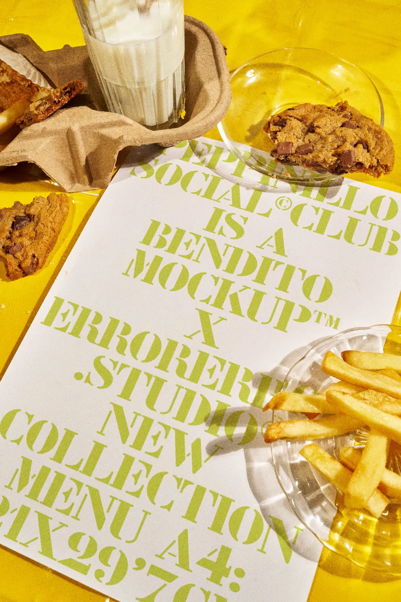 Menu mockup on top of a restaurant table with a yellow tablecloth together with a glass of milk, a cookie and fries. A Format mockup. Restaurant menu PSD file. Print mockup. High-quality menu mockup. A Format PSD high-quality editable file.